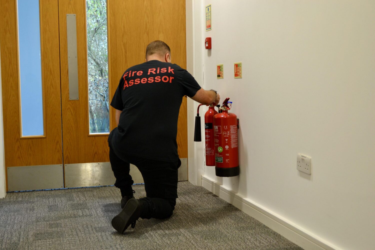 Fire risk assessor inspecting a fire extinguisher