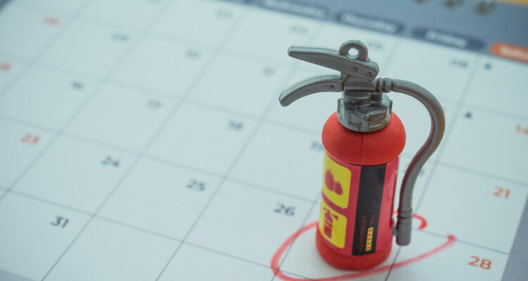 calendar with small fire extinguisher on a date circle in red